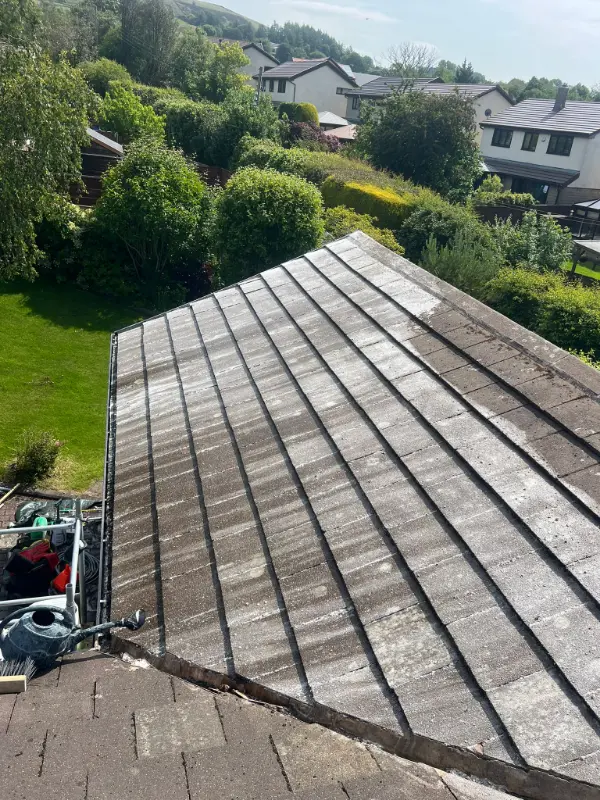 New dark grey fibre cement flat roof panels viewed along the pitch showing a clean even modern surface