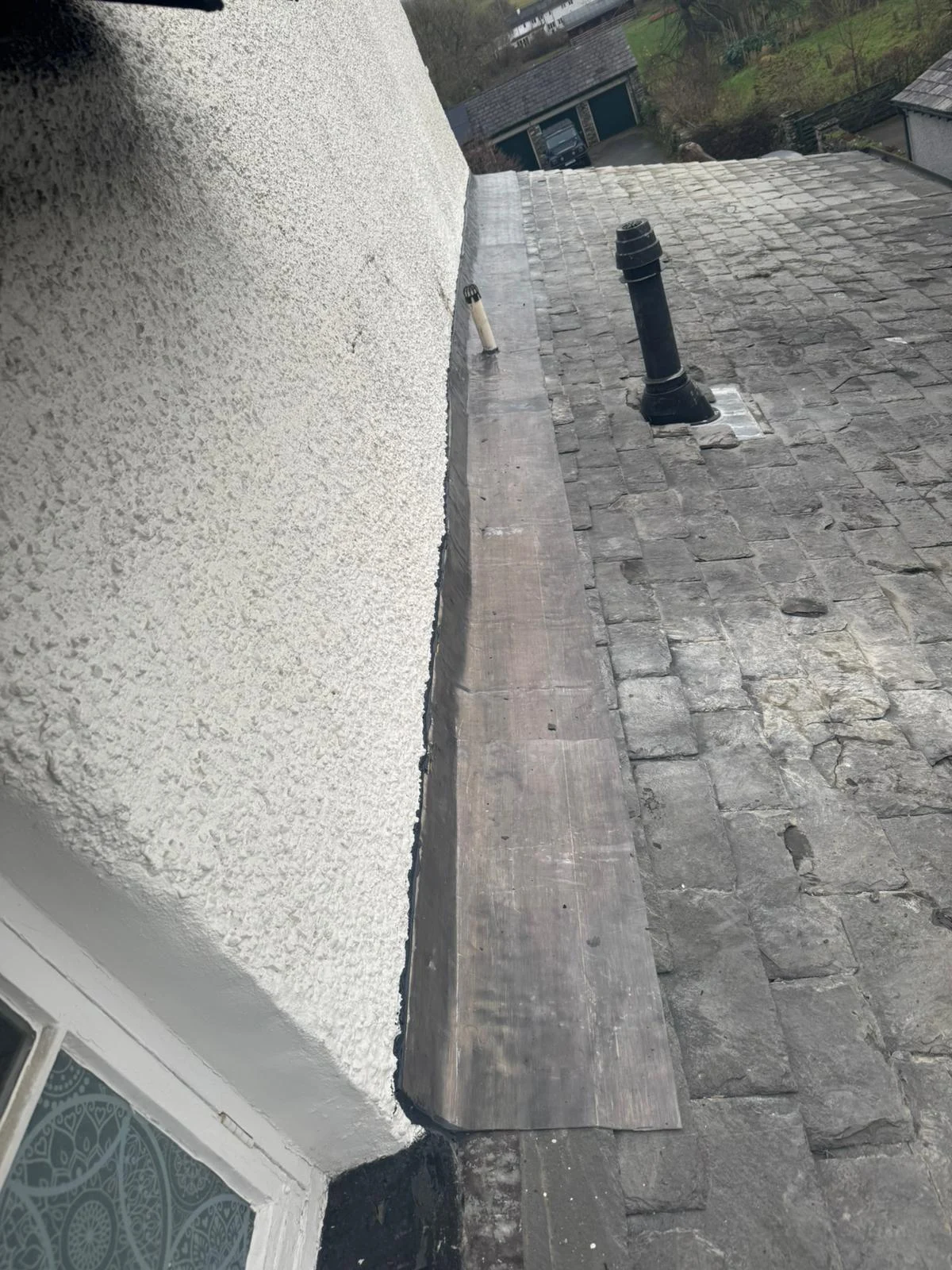 New lead flashing where a pebbledash wall meets an old natural slate roof